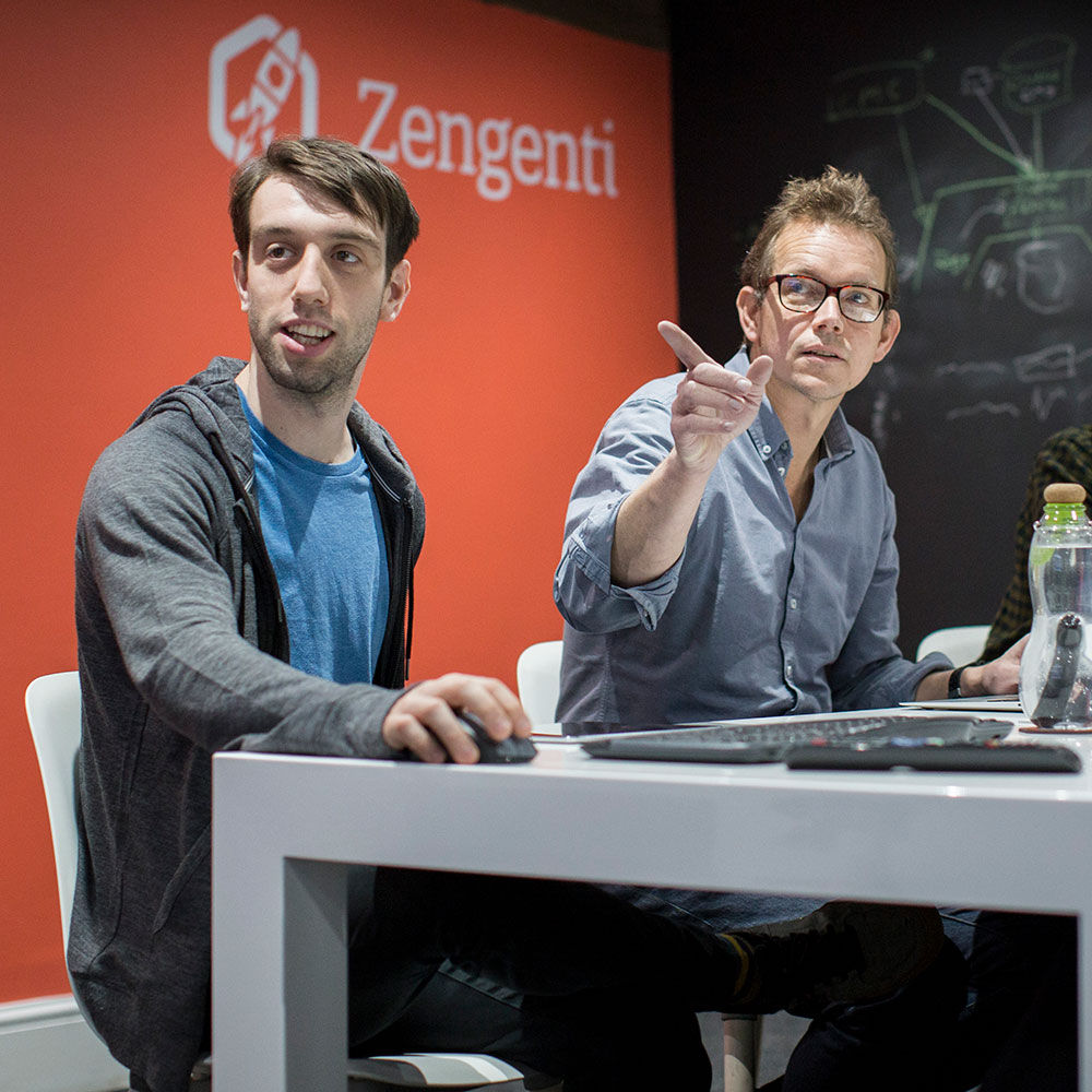 Two men looking at something out of shot during a meeting.